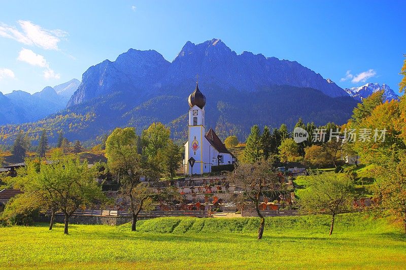 巴洛克式的圣约翰尼斯德尔Täufer教堂在Grainau阿尔卑斯村与Zugspitze, Waxenstein和Alpspitze景观-戏剧性的风景在巴伐利亚阿尔卑斯山，德国，附近的Karwendel山脉-雄伟的高山景观秋天-加尔米施，德国巴伐利亚